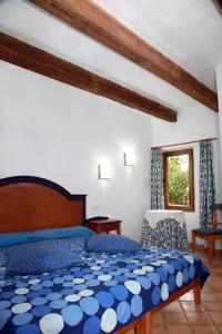 Un dormitorio con una cama azul y blanca y una ventana. en Finca Son Guardiola, en Llucmajor