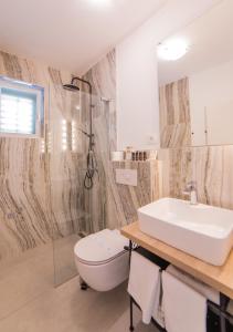 a bathroom with a white sink and a toilet at Villa Astra in Brela +37 photos
