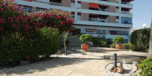 budynek z różowymi kwiatami przed budynkiem w obiekcie Apartamento Calarreona w mieście Águilas