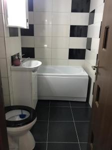 a bathroom with a toilet and a tub and a sink at Apartament Untold in Turda