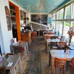 - un restaurant avec des tables et des chaises dans une salle dans l'établissement Sonnevanck Wijk aan Zee, à Wijk aan Zee