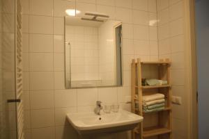 uma casa de banho branca com um lavatório e um espelho em Bed & Breakfast Op 't Leven em Ermelo