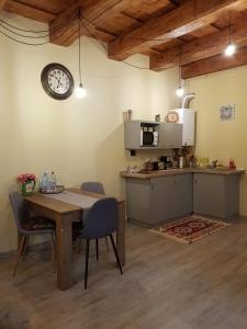 une cuisine avec une table et une horloge murale dans l'établissement Weiss House, à Braşov