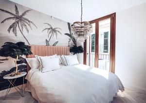 una camera da letto con un grande letto bianco e un lampadario a braccio di Ocho Suites & Kitchen a Palma de Mallorca