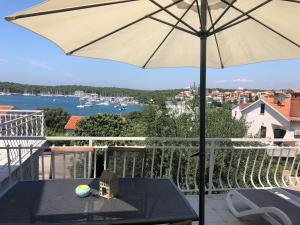 a balcony with a table and an umbrella at Apartments By The Sea in Pula