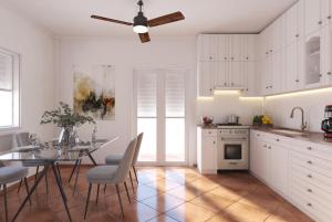 a kitchen with a dining table and a ceiling fan at P & G Apartment in Pámfylla