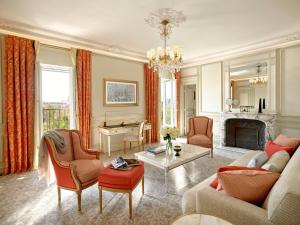 a living room with a couch and a fireplace at Le Meurice – Dorchester Collection in Paris
