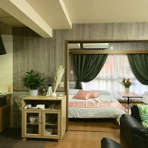 1 dormitorio con cama con dosel y sofá en LaForet inn 303 , en Hiroshima