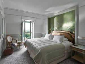a bedroom with a large bed and a green wall at Le Meurice – Dorchester Collection in Paris