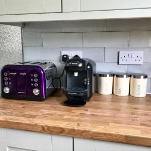 a toaster sitting on a counter next to a toaster gmaxwell gmaxwell at The Woodfarm Lodge - 3 Bedroom House with free Parking in Oxford