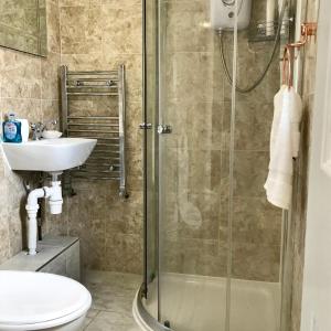 a bathroom with a shower and a sink at The Woodfarm Lodge - 3 Bedroom House with free Parking in Oxford