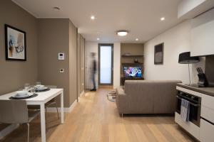 a living room filled with furniture and a tv at Mirabilis Apartments - Bayham Street in London