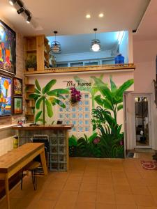 a room with a mural of plants on the wall at Gallery Homestay in Quy Nhon