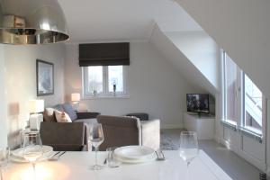 ein Wohnzimmer mit einem Tisch und Weingläsern in der Unterkunft Sylt Flair 9 in Westerland