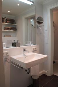 ein Bad mit einem Waschbecken und einem Spiegel in der Unterkunft Sylt Flair 9 in Westerland