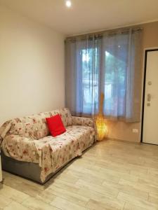 sala de estar con sofá y almohada roja en La casa di Angio c cir D1135, en Lanzo d'Intelvi