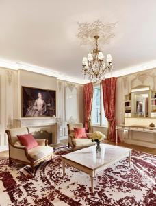 a living room with a chandelier and a table at Le Meurice – Dorchester Collection in Paris