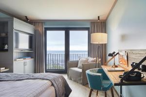 a hotel room with a bed and a desk with a view at Lighthouse Hotel & Spa in Büsum