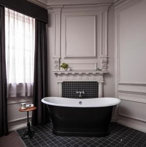 a bathroom with a black and white bath tub at Judges Court in York