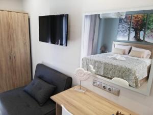 a bedroom with a bed and a chair and a mirror at Haus Viktoria 1 in Limenas