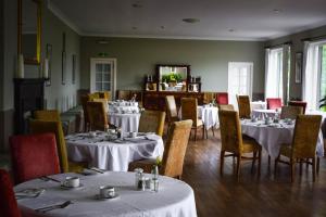 un comedor con mesas y sillas con manteles blancos en The Creggans Inn, en Strachur