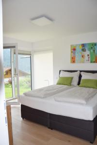 a bedroom with a large bed with green pillows at Ferienhaus Lurger in Strassen