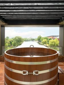 a wooden tub in a room with a view of a river at Olympic Hotel in Amsterdam