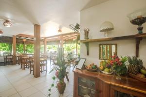 a kitchen and dining room with tables and chairs at Pousada Borboleta in Morro de São Paulo