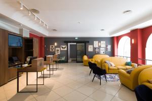 una zona di attesa con sedie gialle e una sala d'attesa di B&B Hotel Palermo Quattro Canti a Palermo