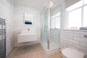 a white bathroom with a sink and a shower at The Beverley by Innkeeper's Collection in Cardiff