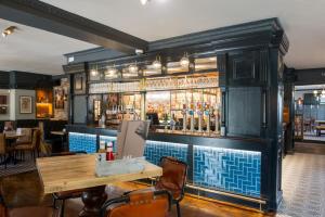 a kitchen with a bar and a table with food on it at The Beverley by Innkeeper's Collection in Cardiff