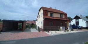 une maison avec garage à côté d'une rue dans l'établissement Apartmán u potoka, à Sadov