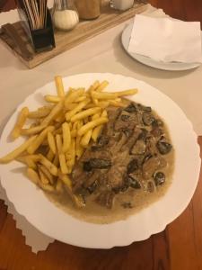 un plato de comida con papas fritas en una mesa en Penzión Príjemný Oddych, en Banská Štiavnica