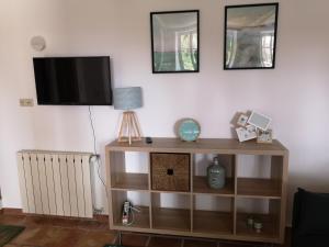 a living room with a tv on a white wall at La Bastide du Limon in Mormoiron