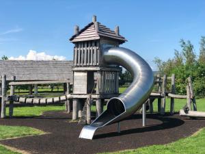 a slide in a park with a bench at Two Bedroom Glen View Free Parking in Inverness