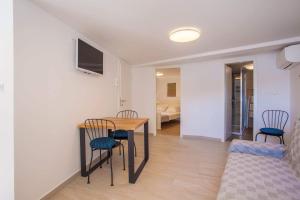 a living room with a table and chairs and a bedroom at Apartmani Kraj mora in Cres