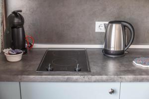 a kitchen counter with a stove with a coffee pot on it at Cloud Studio in Sibiu