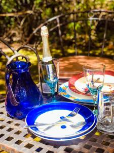 een tafel met borden en wijnglazen en een fles bij Kianderi Villa-Great Rift Valley Resort in Naivasha