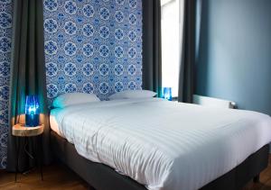sypialnia z dużym łóżkiem z niebieską ścianą w obiekcie Smartflats - High Street w Brukseli
