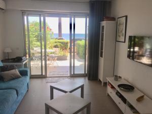 a living room with a blue couch and a view of the ocean at Juan Plage in Juan-les-Pins