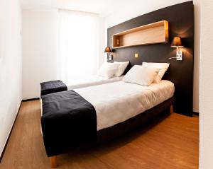 sypialnia z dużym łóżkiem z czarnym zagłówkiem w obiekcie Apparthotel Le Hüb Grenoble w Grenoble