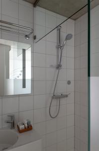 ein Bad mit einer Dusche und einem Waschbecken in der Unterkunft BANKS Antwerp in Antwerpen