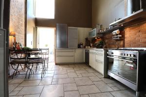 La Villa Blanche في مارسيليا: مطبخ مع أجهزة بيضاء وطاولة مع كراسي