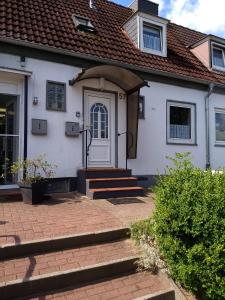 uma casa branca com uma porta branca e escadas em Haus Pries em Kiel