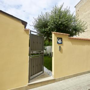 a wooden gate in a yellow wall with a tree at Al Chiaro di Luna in Fondi