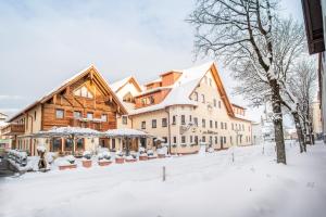 un gran edificio con nieve en el suelo en Wellness-Hotel ADLER, en Bad Wörishofen