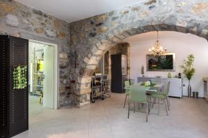 a kitchen and dining room with a stone wall at Muazzo Creta Stone House, a Fairytale Cottage, By ThinkVilla in Pigi