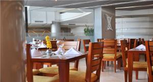 uma sala de jantar com mesas e cadeiras de madeira em Hotel Atrium Plaza em Barranquilla