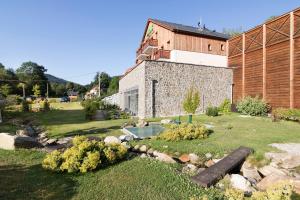 a garden with a stone building and a house at Peras Wellness Hotel in Ludvíkov