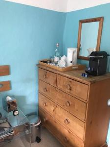 a wooden dresser with a mirror on top of it at The White House in Takeley